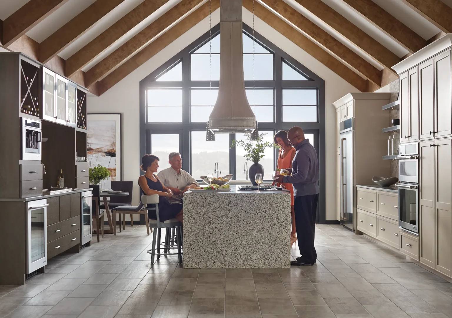 People talking in the center of a large kitchen with custom cabinets