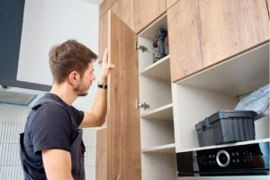 Contractor inspecting shaker-style wood kitchen cabinet doors during cabinet installation